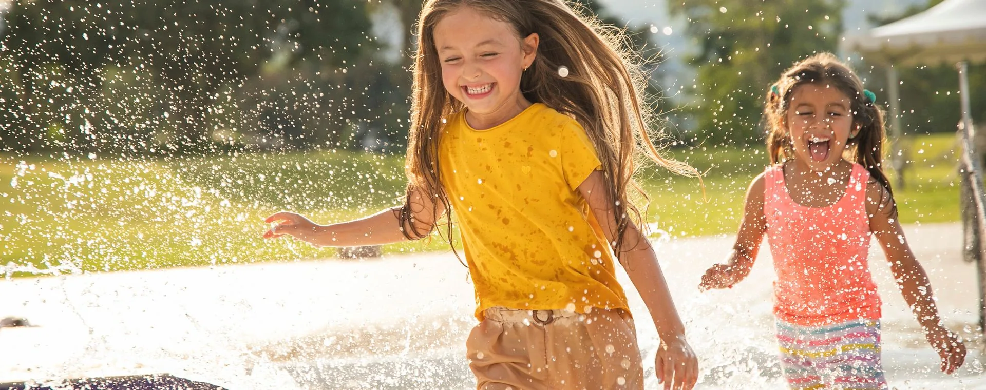 Children running and laughing outdoors in the sunshine