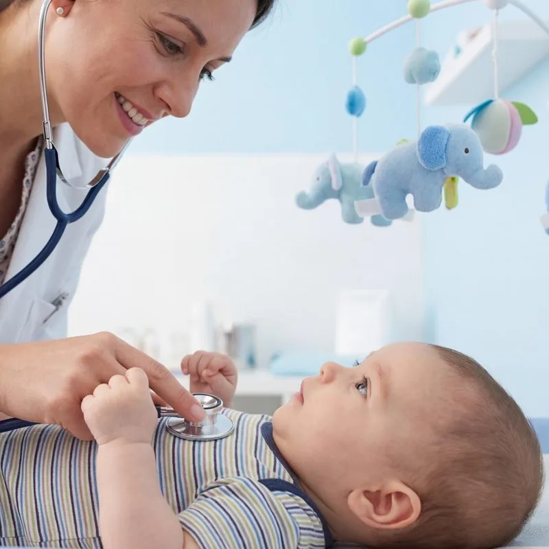 Pediatrician gently examining an infant